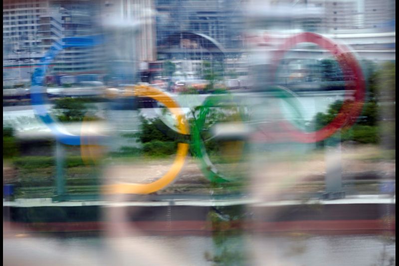A giant Olympic Rings monument is seen through a glass at Odaiba Marine Park in Tokyo, Japan, 12 May 2021 (issued 13 May 2021).