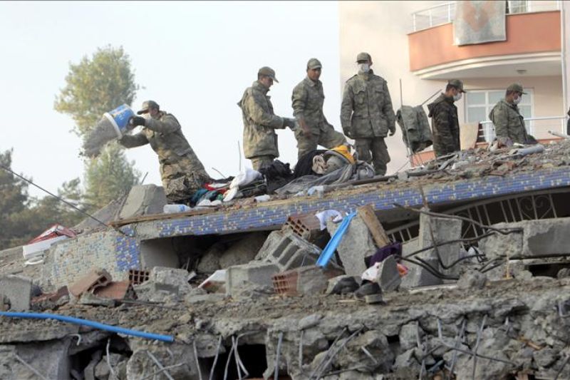 Soldados turcos desalojan a una familia que permanece sobre los escombros de un edificio que colapsó durante el terremoto de 7,2 grados en la escala de Richter que se registró el domingo en el este de Turquía, en la localidad de Ercis