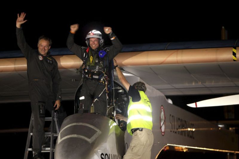 Los pilotos suizos del avión solar "Solar Impulse" Bertrand Piccard (c) y André Borschberg (i) saludan en el aeropuerto de Rabat, Marruecos, tras cumplir su sueño de unir Europa y África y volar sin combustible durante 19 horas seguidas desde Madrid a una