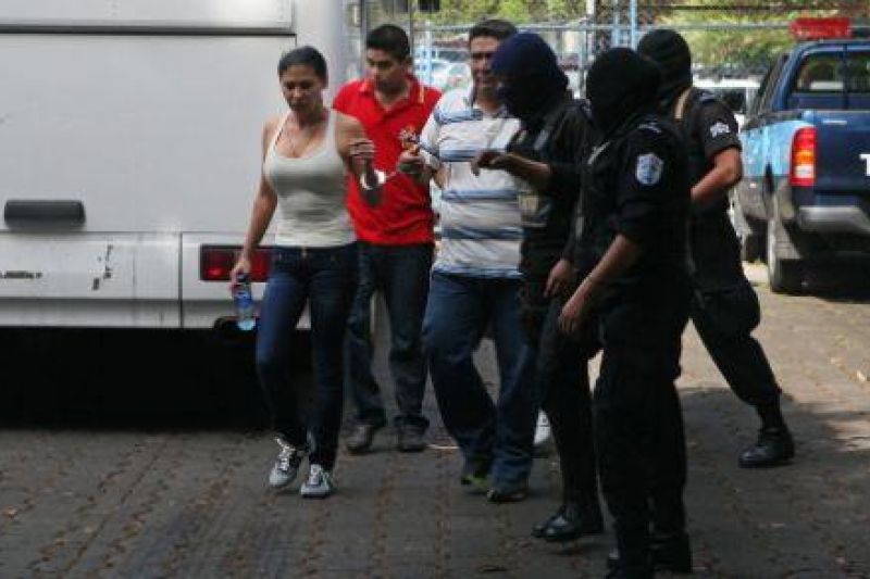 En la imagen, la mexicana Raquel Alatorre Correa, identificada como la líder del grupo de 18 falsos periodistas de Televisa detenidos con 9 millones de dólares, es conducida por miembros de las fuerzas especiales de la Policía Nacional para una audiencia.