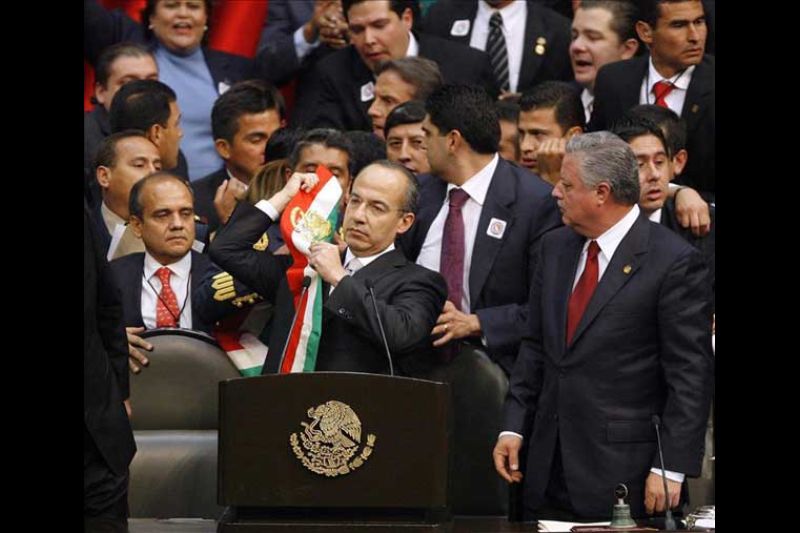El presidente de México, Felipe Calderón, se pone la banda presidencial durante la toma posesión el 1 de diciembre de 2006, ante el Congreso de la Unión en la Ciudad de México, como presidente de México para el periodo 2006-2012.