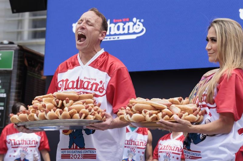 Joey Chestnut (L) y Miki Sudo (R) posan con platos de hot dogs durante una ceremonia de pesaje parael la competencia de perros calientes de Nathan's en Nueva York, Nueva York, EE. UU., este 3 de julio de 2023. EFE/EPA/Justin Lane