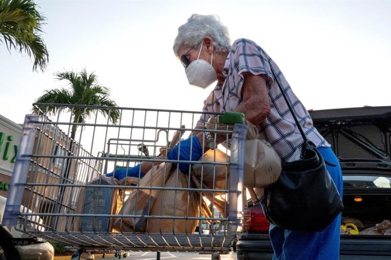 Una mujer carga sus compras del Publix Supermarket en Miami, Florida, USA, el 21 de abril del 2020.