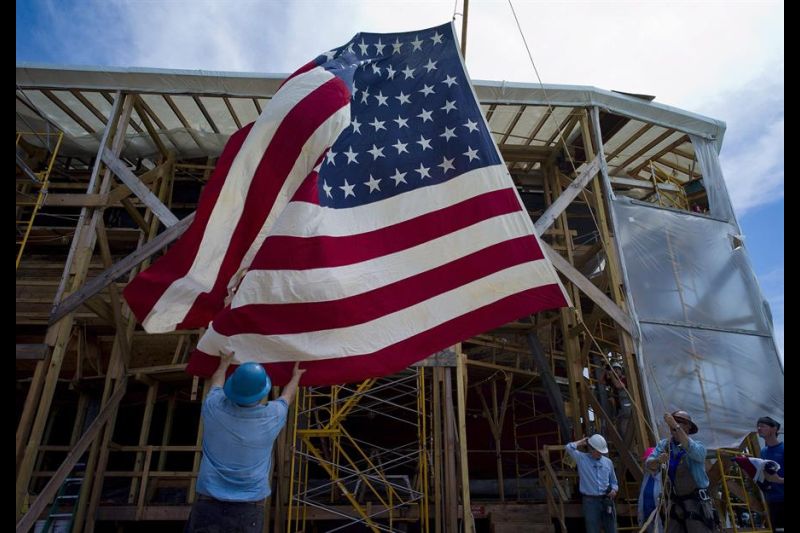 Imagen de archivo de unas personas que recogen una bandera de los EE. UU. mientras se preparan para ceremonia del aniversario del ataque de Japón a la base naval de Pearl Harbor en Hawái. EFE/EPA/CJ GUNTHER