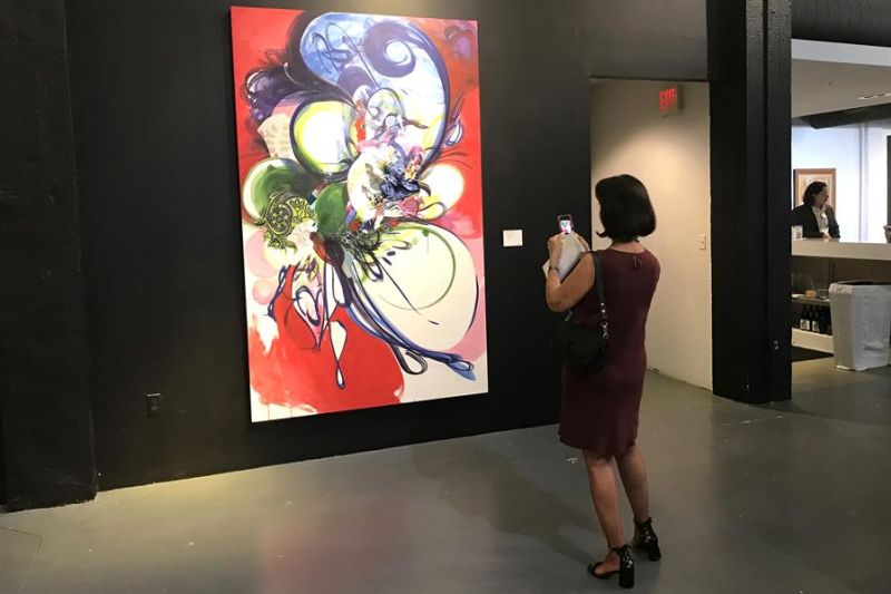 Una mujer toma una fotografía con su teléfono móvil a la obra "Rose Colored Times" (2009) de Shinique Smith este 12 de septiembre de 2022, en un espacio del Distrito del Diseño de Miami, Florida (EEUU). EFE/Ana Mengotti