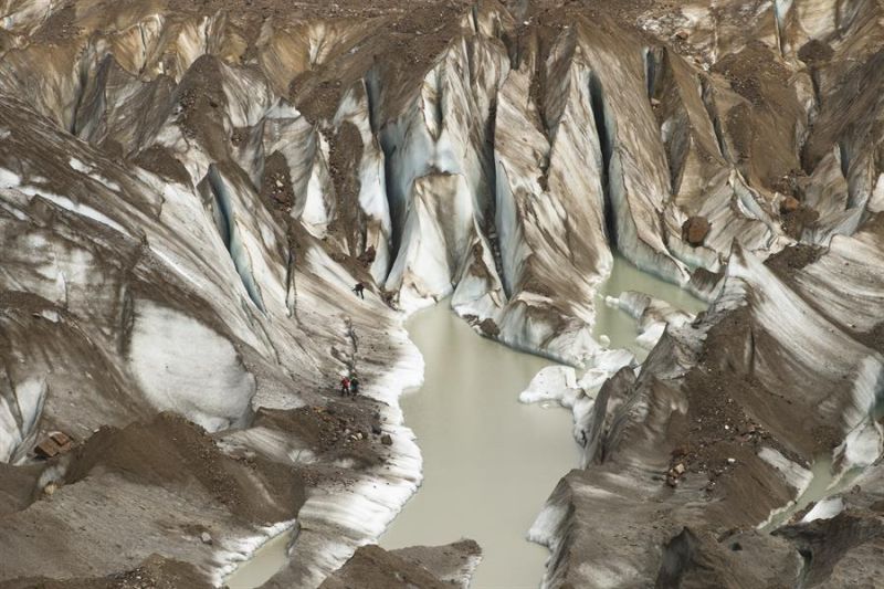 Funcionarios de la Corporación Nacional Forestal (CONAF) caminan por una zona de deshielo próxima al glaciar Exploradores, el 14 de febrero de 2022, en el Parque Nacional Laguna San Rafael, en la región de Aysén (Chile). EFE/ Alberto Valdes