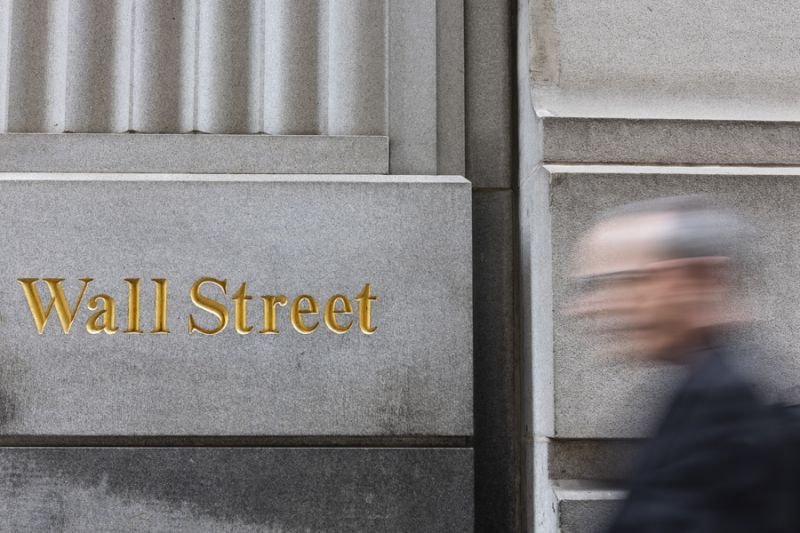 Imagen de archivo de un peatón caminando junto a un letrero de Wall Street cerca de la Bolsa de Nueva York. EFE/EPA/JUSTIN LANE