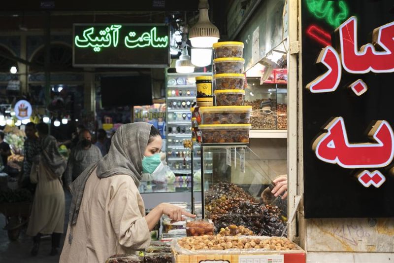 Una mujer compra en un puesto del bazar de Tajrish, en el norte de Teherán. Los iraníes aguardan con pocas expectativas la reactivación del pacto nuclear de 2015, que supondría el levantamiento de las sanciones estadounidenses. EFE