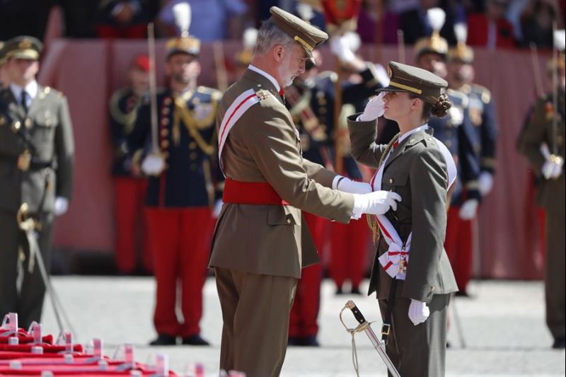 Felipe VI impone la banda a su hija, la princesa Leonor, durante la ceremonia en la que le entregó su despacho de alférez tras un año en la Academia General Militar de Zaragoza (norte). EFE/ Javier Cebollada