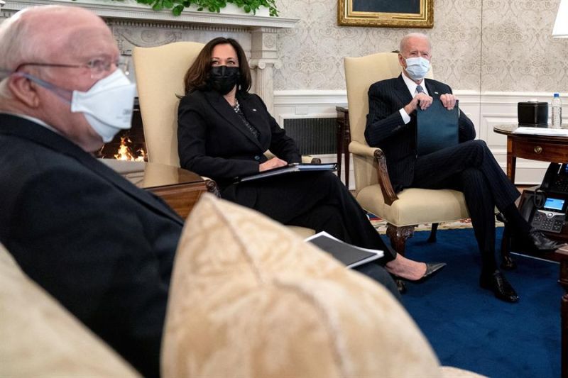 El presidente estadounidense Joe Biden (d), lleva una máscara protectora mientras se reúne con la vicepresidenta Kamala Harris (c), y los senadores demócratas en la Oficina Oval de la Casa Blanca en Washington, DC, Estados Unidos, 03 de febrero de 2021.