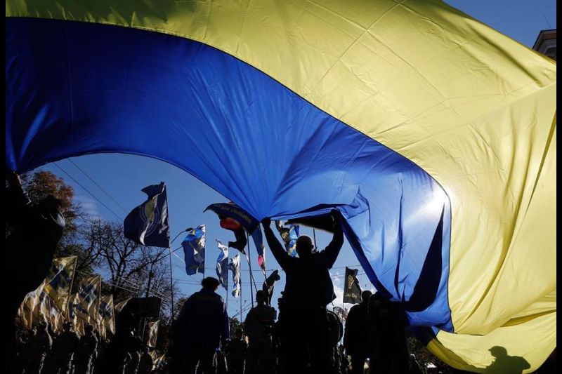 Fotografía de archivo de un grupo de personas ondeando una bandera nacional ucraniana gigante en el centro de Kiev. 01 191022