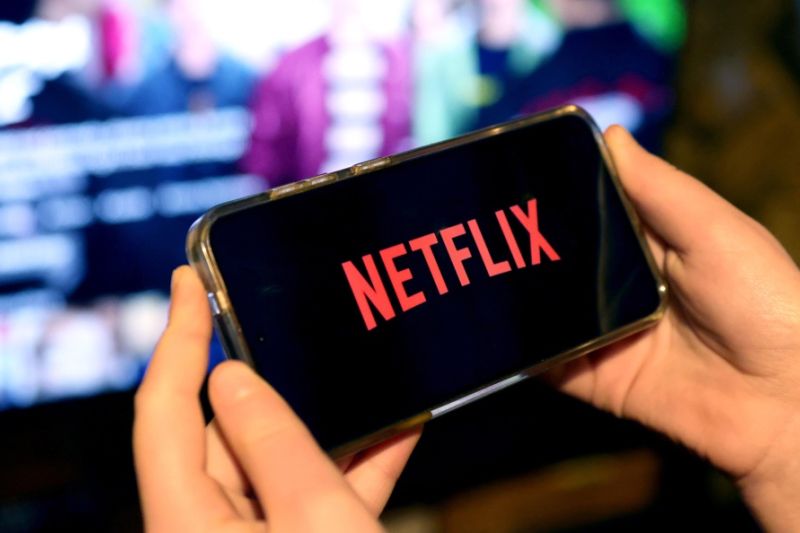 Fotografía de archivo en donde una persona sostiene en sus manos un teléfono con la aplicación de Netflix. EFE/NEIL HALL