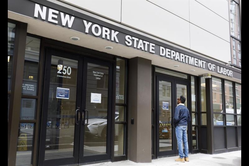 Un hombre lee un cartel en la puerta de las oficinas cerradas del Departamento de Trabajo del Estado de Nueva York en Brooklyn. EFE/EPA/JUSTIN LANE 01 050523