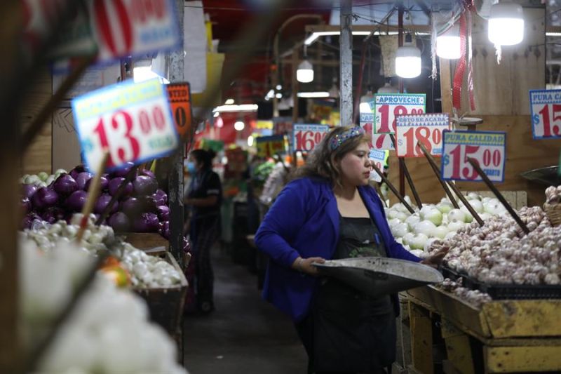 Una comerciante organiza sus productos en un mercado en el que resaltan carteles con precios hoy, en la Ciudad de México. 01 090222