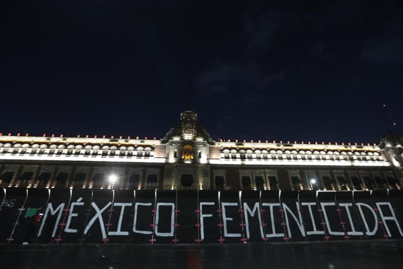 Fotografía de la frase "México feminicida" escrita por colectivos feministas en una valla frente al Palacio Nacional, en Ciudad de México (México).
