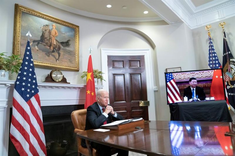 El presidente de Estados Unidos, Joe Biden (c), fue regitrado este lunes al escuchar a su homólogo chino, Xi Jinping (en pantalla), durante un encuentro virtual, en el salón Roosevelt de la Casa Blanca, en Washington DC (EE.UU.).