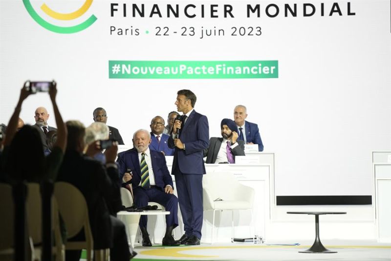 El presidente de Francia, Emmanuel Macron (de pie), en la sesión de clausura de la Cumbre del Nuevo Pacto Financiero Mundial, mientras escucha el presidente de Brasil, Luiz Inacio Lula Da Silva (C, sentado), en París. EFE/EPA/Lewis Joly / POOL MAXPPP OUT 