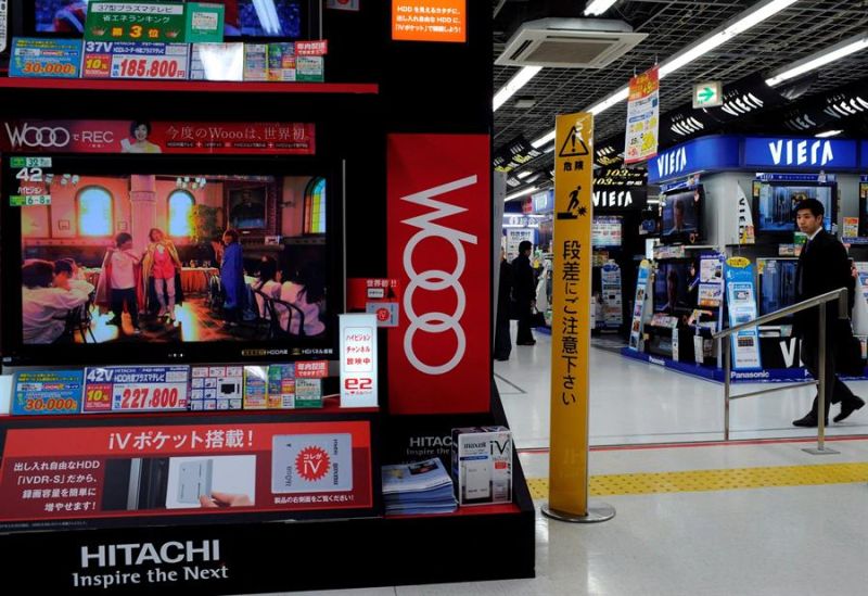 Un cliente de productos electrónicos pasa junto a un mostrador de la compañía Hitachi que exhibe una pantalla de televisión plana de LCD en Tokio (Japón). 