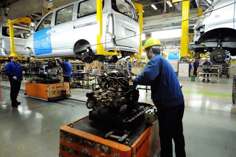 Varios empleados trabajan en una fábrica de ensamblaje de minivans en Qingdao (China).