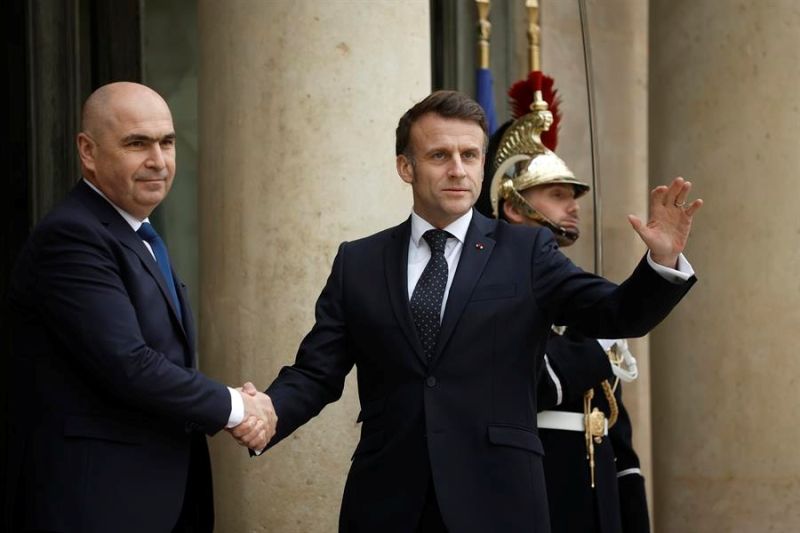 El presidente francés Emmanuel Macron (D) saluda al presidente interino rumano Ilie Bolojan (I) a su llegada al Palacio del Elíseo para participar en una reunión por videoconferencia sobre la guerra en Ucrania y la seguridad europea en París, Francia, 19 