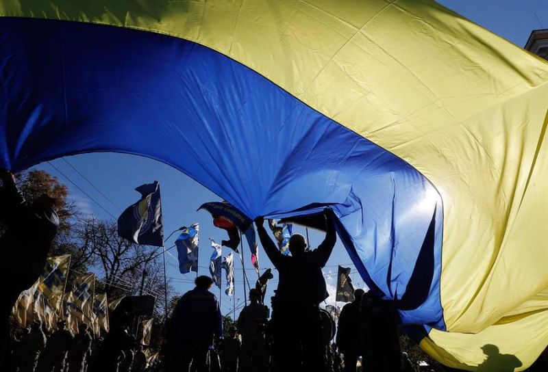 Fotografía de archivo de un grupo de personas ondeando una bandera nacional ucraniana gigante en el centro de Kiev. 01 191022
