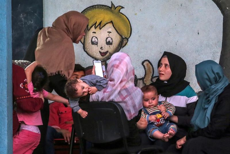 Imagen faciitada este jueves, 20 de mayo, que muestras a varias mujeres palestinas y sus hijos refugiados en una escuela de la ONU en la ciudad de Gaza.