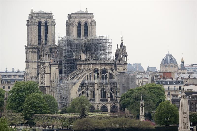 Vista de la estatua de Santa Genoveva (dcha, delante), patrona de la ciudad, en el puente Pont de la Tournelle, con la catedral de Notre Dame al fondo, en París (Francia).